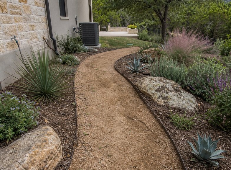 garden path with native plants and boulders